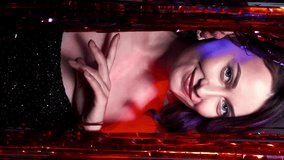 Vertical video. Holiday event. Party look. Female charm. Festive atmosphere. Pretty woman elegant dress flirt hiding in red shimmering cascade curtain. - Powered by Shutterstock - Get 15% off with code: PIKWIZARD15