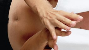 Vertical video. Hand care. Skin moisturizing. Unrecognizable athletic shirtless man with towel applying cream from tube rubbing palms with fingers isolated on white. - Powered by Shutterstock - Get 15% off with code: PIKWIZARD15