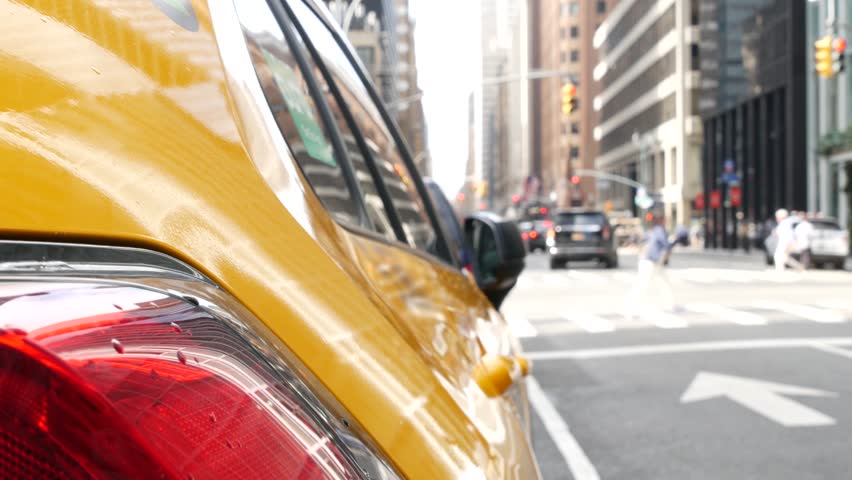 New York City. Yellow taxi car on Manhattan street. Taxi cab on Midtown Lexington avenue. Medallion taxicab rear view on Lex ave waiting for people or passengers on road. Urban scene in United States.