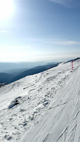 Ski resort, winter sports, view of snow-capped mountains and ski slopes on a sunny day, going up the mountain on a ski lift.