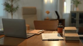 Warm office desk showing a closed laptop, documents, coffee and decorated background, with a comfortable chair slightly out of focus, perfect for corporate and business video projects - Powered by Shutterstock - Get 15% off with code: PIKWIZARD15