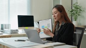 Young businesswoman presenting financial graph via video conference in the office, pointing at a chart explaining the details of the business performance - Powered by Shutterstock - Get 15% off with code: PIKWIZARD15