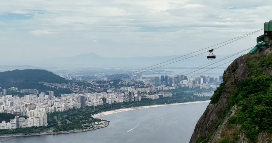 Cable cars pass each other on the way to Sugar Loaf Mountain. City wide angle view, Rio de Janeiro