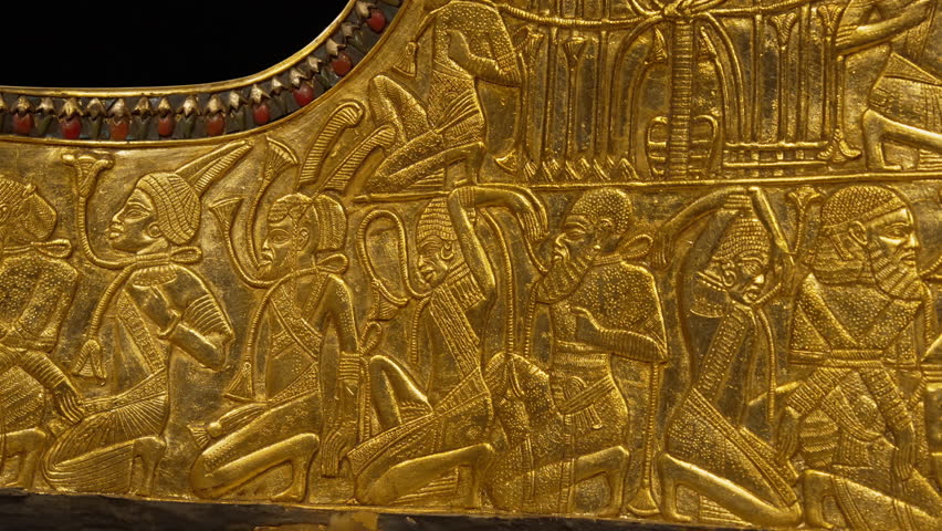 Detailed macro view of Tutankhamun parade chariot. Gilded surfaces carvings with golden Egyptian Hieroglyphs, ancient Egypt exhibit in museum