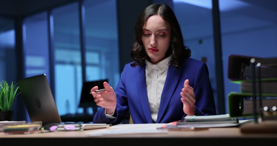 Angry woman manager checks report crossing wrong blocks at late hours in office. Woman analyzes business papers preparing commercial presentation