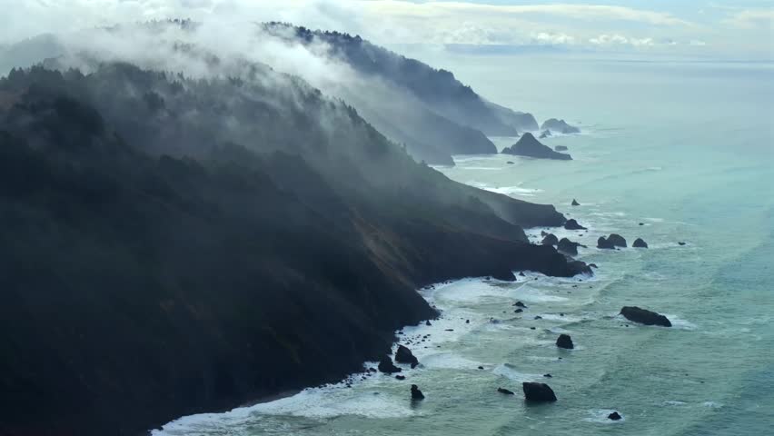 Rugged coastline Lost Coast Trail USAL Beach campground 4wd black sand mist rain fog aerial drone California PNW waves crashing cloud layer morning Chimney Rocks nature landscape backwards motion