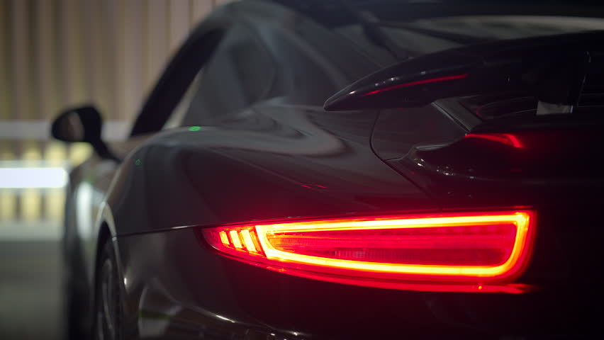 A sleek black sports car sits confidently in an urban setting, perfect for thrilling adventure