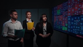 Woman chief executive leads meeting with colleagues in boardroom, explaining stock exchange and currency rates infographics on big display in real time. - Powered by Shutterstock - Get 15% off with code: PIKWIZARD15