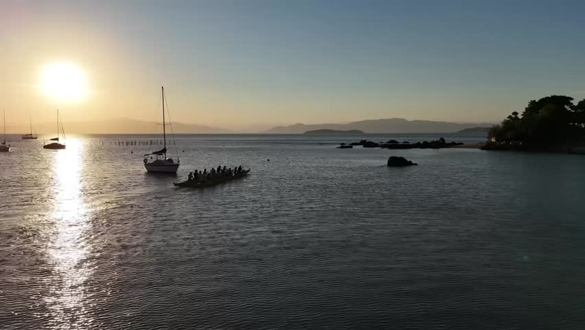 Sunset Paddleboarding – Aerial Serenity Over the Ocean , Experience the breathtaking beauty of a sunset over the ocean, captured from a drone’s perspective