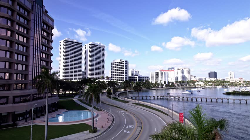 Establishing drone shot of downtown West Palm Beach with palm trees, roads and Lake Worth Lagoon in Florida, USA