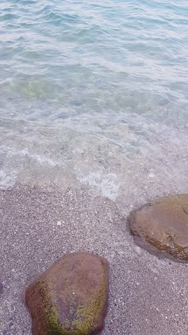 Calm Shoreline with Clear Waters and Stones at Lake Garda, Italy.