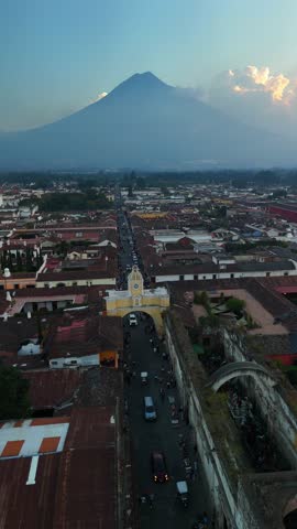 Vertical Drone view of the Iglesia de la Merced church and the Santa Catalina Arch in Antigua, Guatemala. View of the Agua volcano.
