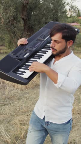 Pianist Man Walks Playing Musical Keyboard On Shoulder In Nature Of Sicily