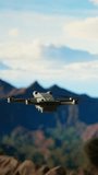 Vertical Video Traveler balances adventure and creating content by filming with his drone, recording the aerial view of a beautiful mountain range. Breathtaking landscape scenery videography. Camera A - Powered by Shutterstock - Get 15% off with code: PIKWIZARD15
