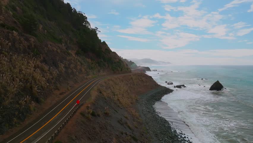 Shoreline Pacific Coastal Highway 1 DeHaven Westport Fort Bragg aerial drone California rugged Coastline blue sky surf waves crashing boulder rocks mountain side clouds Pacific Ocean forward motion