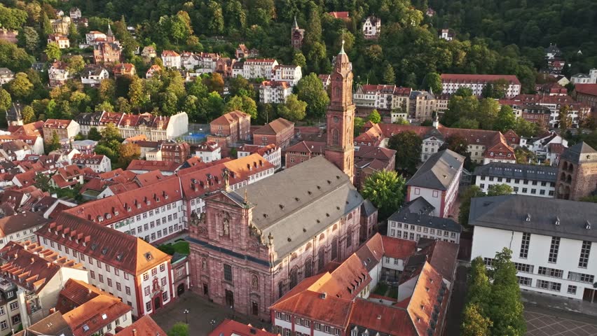 A stunning aerial drone view of Jesuit Church ( Jesuitenkirche ) in Heidelberg, Germany, showcasing its magnificent Baroque architecture, historic significance, and picturesque location .