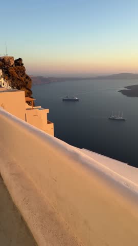 Beautiful sunset in Santorini island, Greece. White architecture with sea view. Blue sea and the blue sky at sunset. Summer travel and vacation. Vertical video
