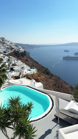 White architecture in Santorini island, Greece. Luxury swimming pool with blue water. Blue sea and the blue sky at sunny day. Travel and summer vacation concept. Vertical video
