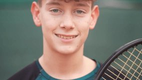 Portrait zoom out of a handsome teenage boy with red hair and blue eyes looking at the camera and smiling on a tennis court. Tennis player.

 - Powered by Shutterstock - Get 15% off with code: PIKWIZARD15