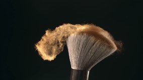 Super slow motion macro shot of makeup brush and golden shiny face powder shake at 1000 fps. Elegant luxury make up cosmetic abstract background. Beauty make-up glitter flying in high speed close up - Powered by Shutterstock - Get 15% off with code: PIKWIZARD15