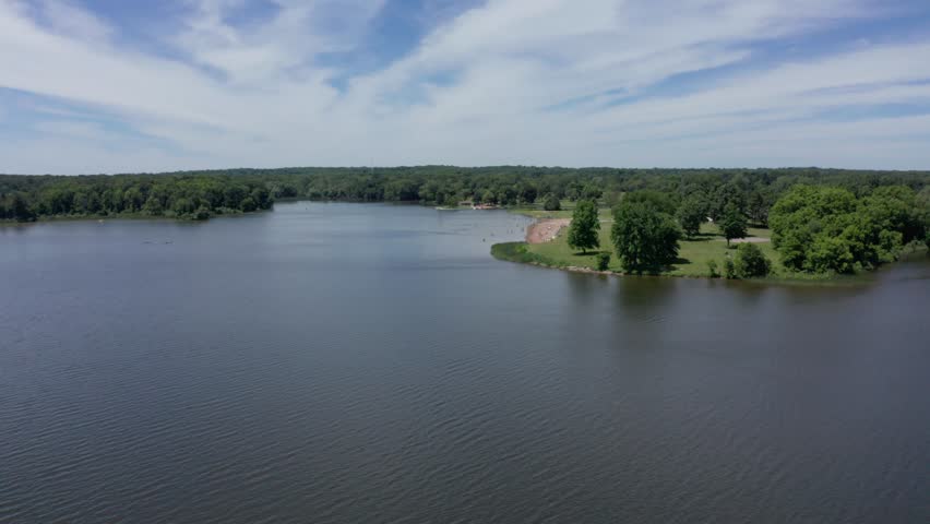 Drone Footage of Lake in Michigan in Summer with people on beach and a volleyball court