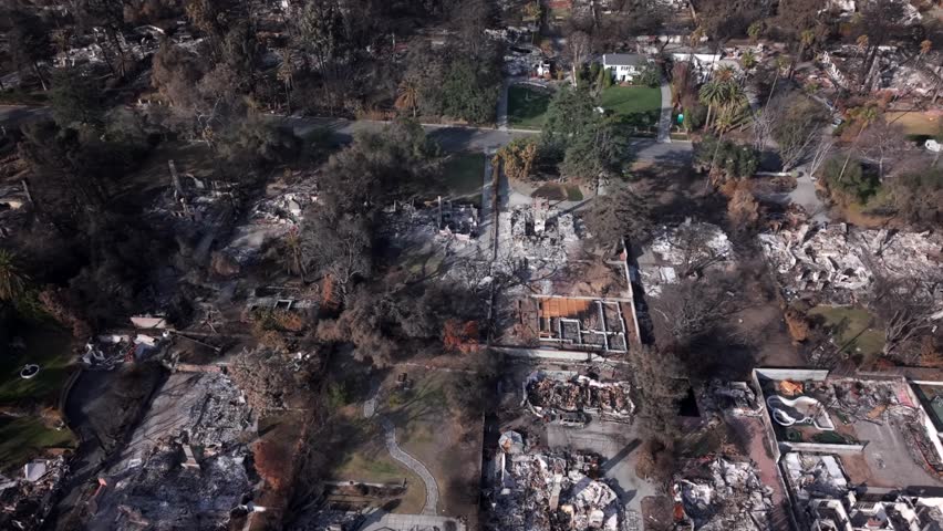 Aerial view of lone house standing untouched amidst scorched neighborhood and devastation of Eaton Canyon Fire in Altadena