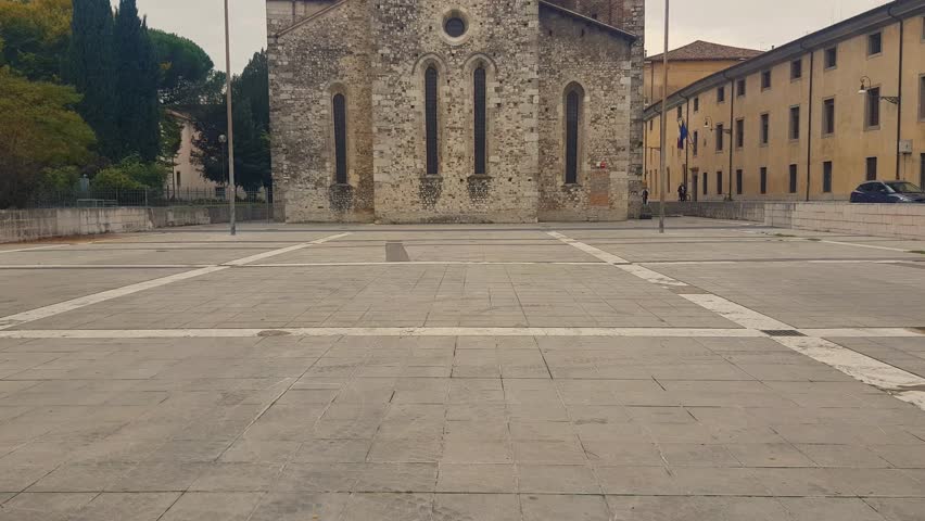 Revealing shot of the Romanesque-Gothic Church of San Francesco in Udine, showcasing its simple yet elegant architecture, embodying the Franciscan ideals of humility and devotion
