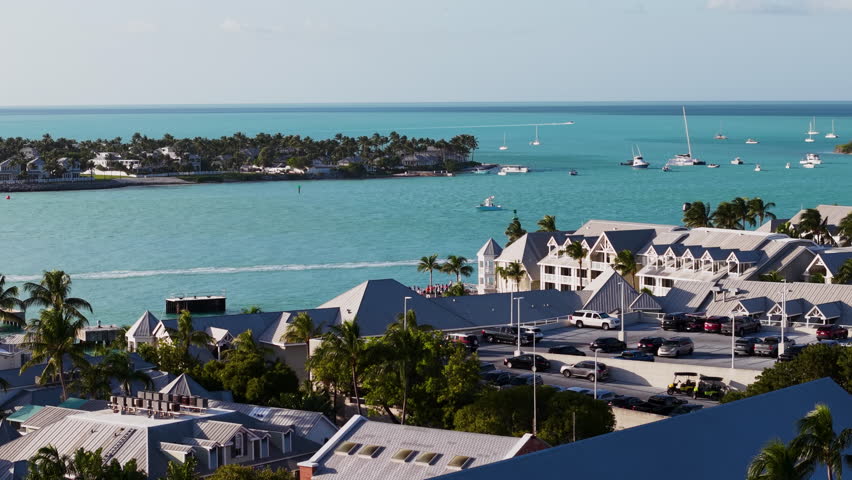 Aerial view of the oastline of Key West with boats driving by, sunset in Florida