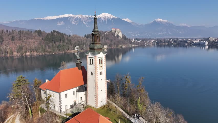 A detailed aerial view of the Church of the Assumption on Bled Island, Slovenia. The video showcases the stunning architecture of the historic church, surrounded by the tranquil waters of Lake Bled.