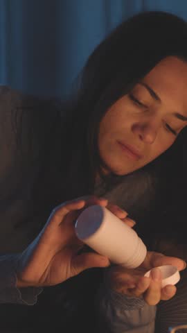 Young woman waking up at night and taking pills, healthcare and medicine concept