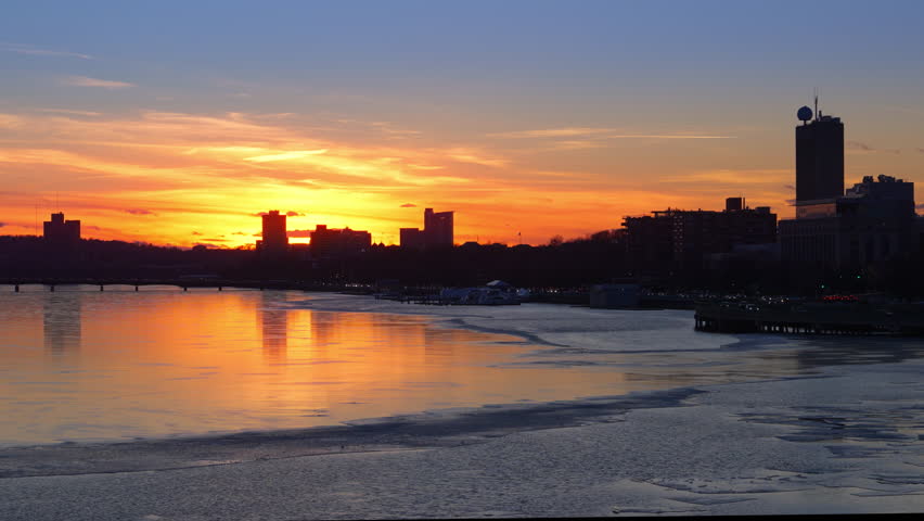 Silhouette view of Boston city skyline with high-rise buildings seen from  Longfellow bridge over Charles river during winter sunset