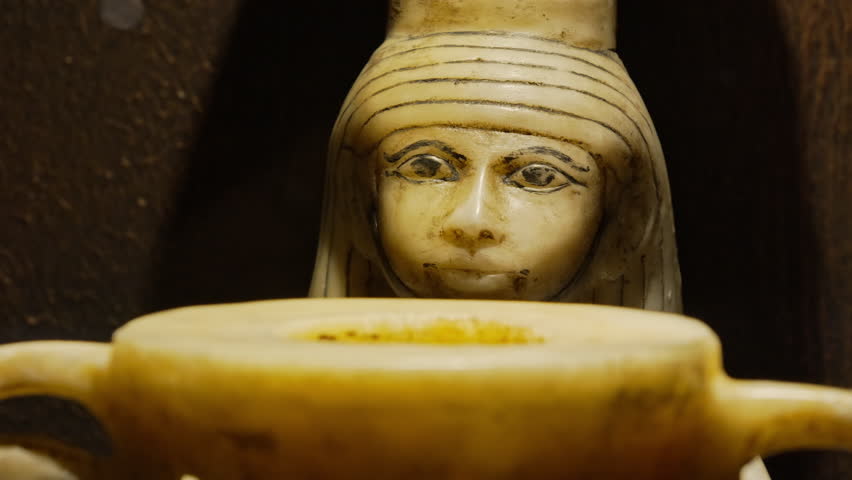 Ancient Egyptian canopic statue, intricately carved. Guard preserved organs during mummification.