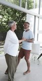 Vertical video: Dancing together, elderly couple enjoying time at home, smiling and holding hands. Seniors, lifestyle, happiness, romance, indoors, loving - Powered by Shutterstock - Get 15% off with code: PIKWIZARD15