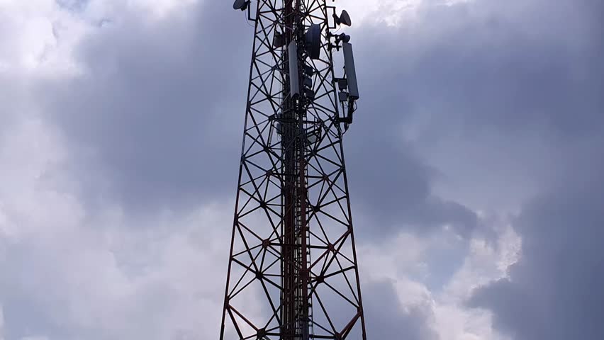 Telecommunication tower against a cloudy sky.