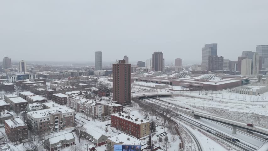 Aerial view of Minneapolis showcasing a mix of high-rise buildings, residential neighborhoods and snow-covered streets in winter