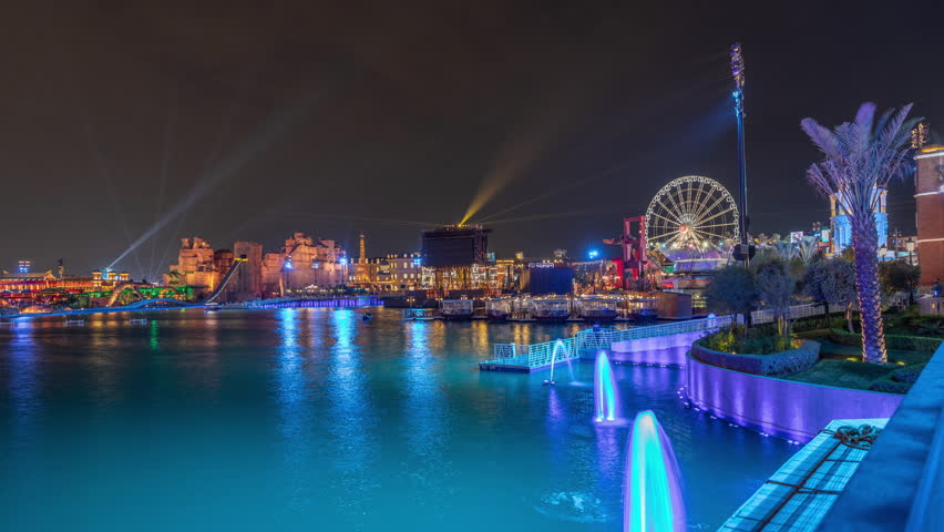 Panorama showing Riyadh Boulevard World entertainment park with illuminated attractions famous landmarks. Largest artificial lake on the world with floating boats night timelapse. Riyadh. Saudi Arabia