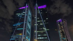 Modern skyscrapers on the Olaya street timelapse. Looking up perspective view to illuminated towers with glowing windows. Near shopping mall. Clouds on the dark sky. Riyadh, Saudi Arabia - Powered by Shutterstock - Get 15% off with code: PIKWIZARD15