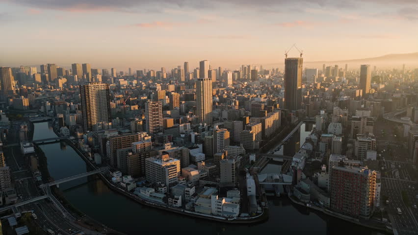 osaka city central minami ward aerial view drone at sunrise,flying over kizu river,high-rise office buildings in the background,metropolis cityscape - Powered by Shutterstock - Get 15% off with code: PIKWIZARD15