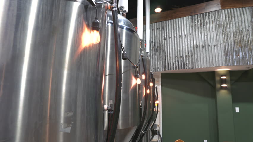 4k footage of Edison bulbs hanging on a fermenter at a brewery