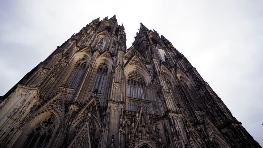 An awe-inspiring upward view of the intricate Gothic facade of Cologne Cathedral, highlighting its towering spires and ornate architectural details.