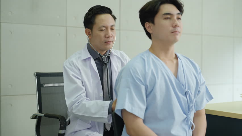 Healthcare doctor using stethoscope to listen to male patient lungs during medical exam. Hospital care, physical assessment, respiratory health and professional medical consultation.