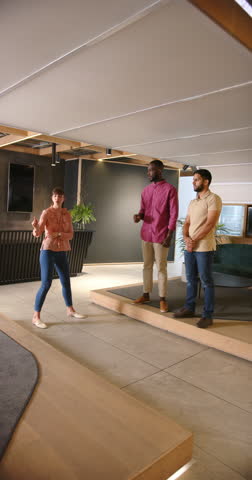 Vertical video: Presenting ideas, woman speaking to two colleagues in modern office setting. Business, teamwork, collaboration, presentation, meeting, brainstorming