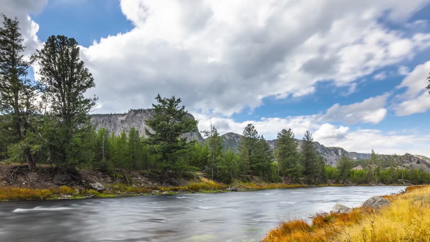 Time lapse of the clouds moving over the landscape of Yellowstone National Park in Wyoming. Madison River in the foreground.