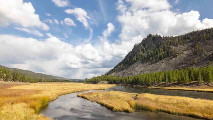 Time lapse of the clouds moving over the landscape of Yellowstone National Park in Wyoming. Madison River in the foreground.