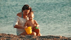 Mother with Child on Summer Beach at Evening
