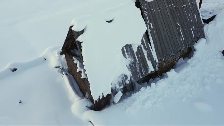 Aerial video of thick snow sliding off the roof