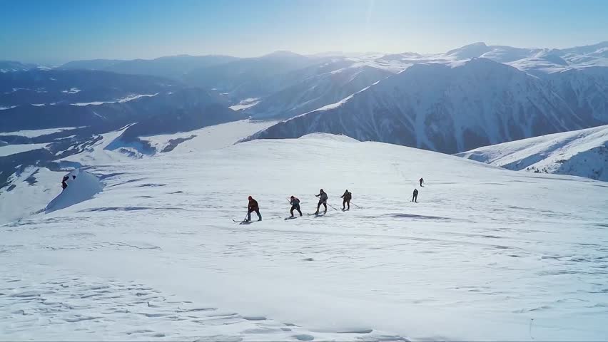 video of a group of people wearing skis climbing a snowy mountain