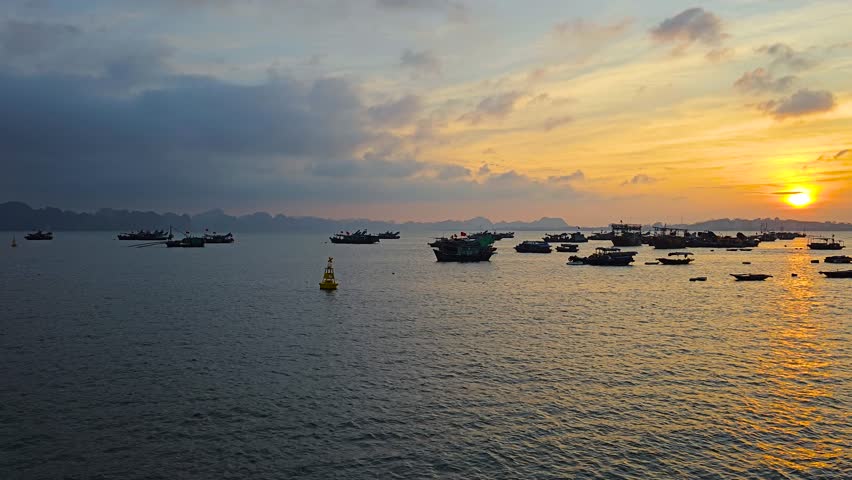 Fishing Boats On Ha Long Bay At Golden Hour Sunset In Quang Ninh, Vietnam. wide static shot