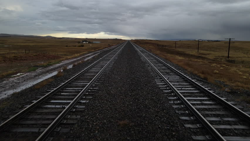 Railroad Tracks in, rural Wyoming, USA— Aerial Shot Rising from Track Level up to Wide Landscape