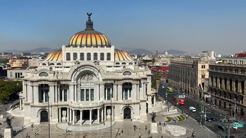 A high angle timelapse of Palace of Fine Arts with people walking around, and the traffic nearby on a sunny day with clear sky in Mexico City, Mexico